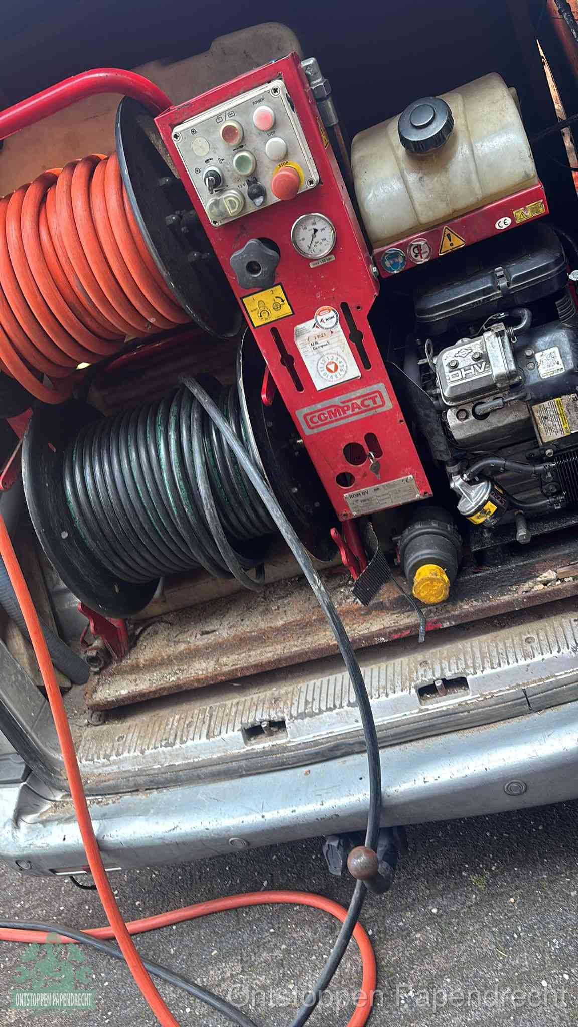 Een rood hogedruk-rioolreinigingstoestel in de laadbak van de bedrijfsbus, apparatuur voor een hardnekkige afvoerverstopping in Papendrecht