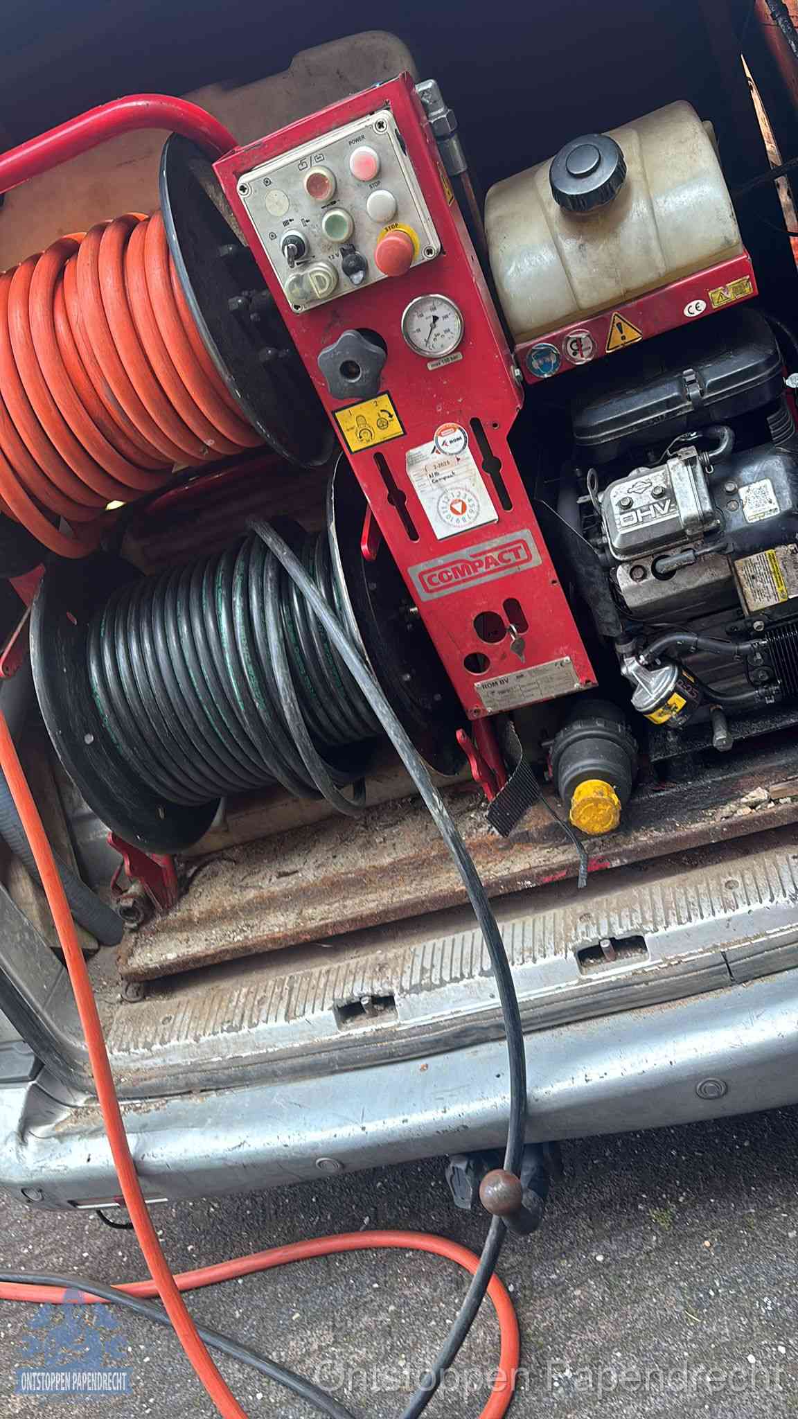 Een rood hogedruk-rioolreinigingstoestel met slangen in de laadbak van de bedrijfsbus, apparatuur voor een hardnekkige wc-verstopping in Papendrecht