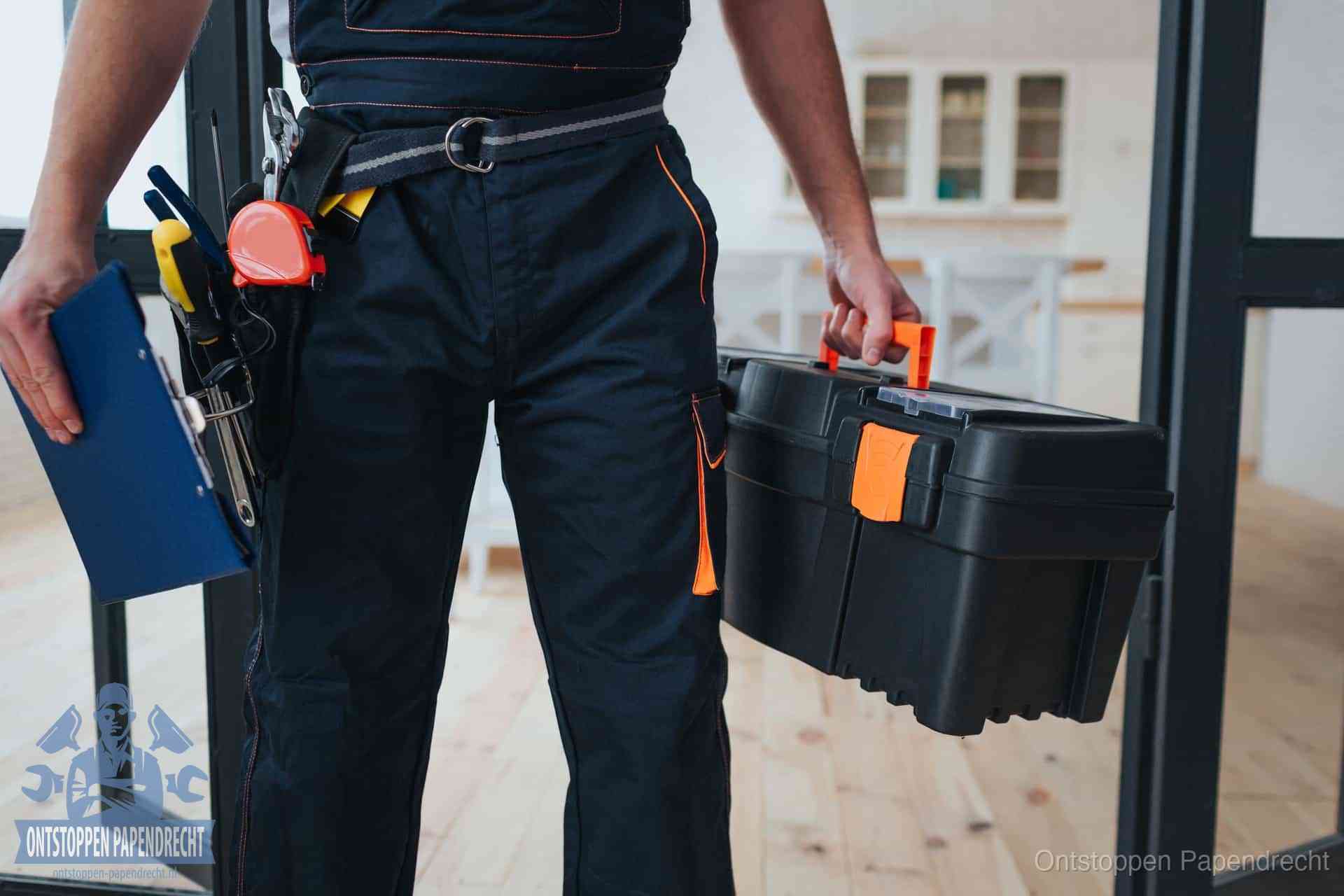 Een monteur met gereedschapsriem en klembord, klaar om een transparante prijs voor het wc ontstoppen in Papendrecht te geven
