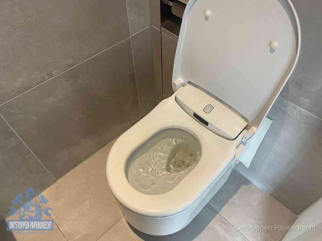 Een toiletpot vol troebel water met drijvend papier en restanten, de meest voorkomende oorzaak van een verstopte wc in Papendrecht