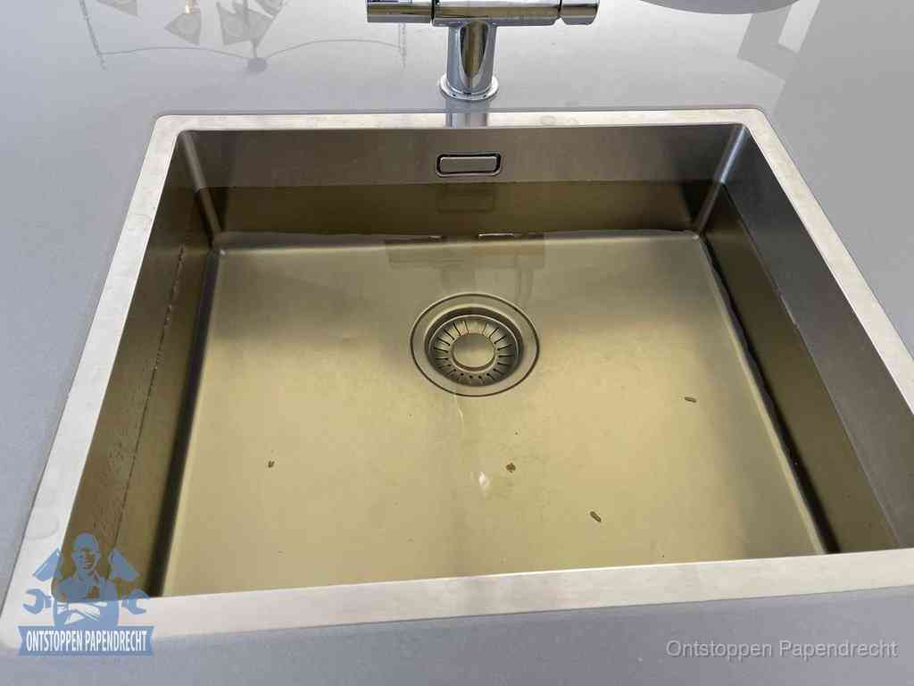 Stilstaand water in een rvs spoelbak dat niet wegloopt, een duidelijk signaal van een gootsteenverstopping in Papendrecht