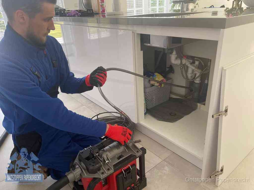 Een monteur reinigt de keukenafvoer grondig met een veermachine om terugkerende gootsteenverstoppingen te voorkomen in Papendrecht