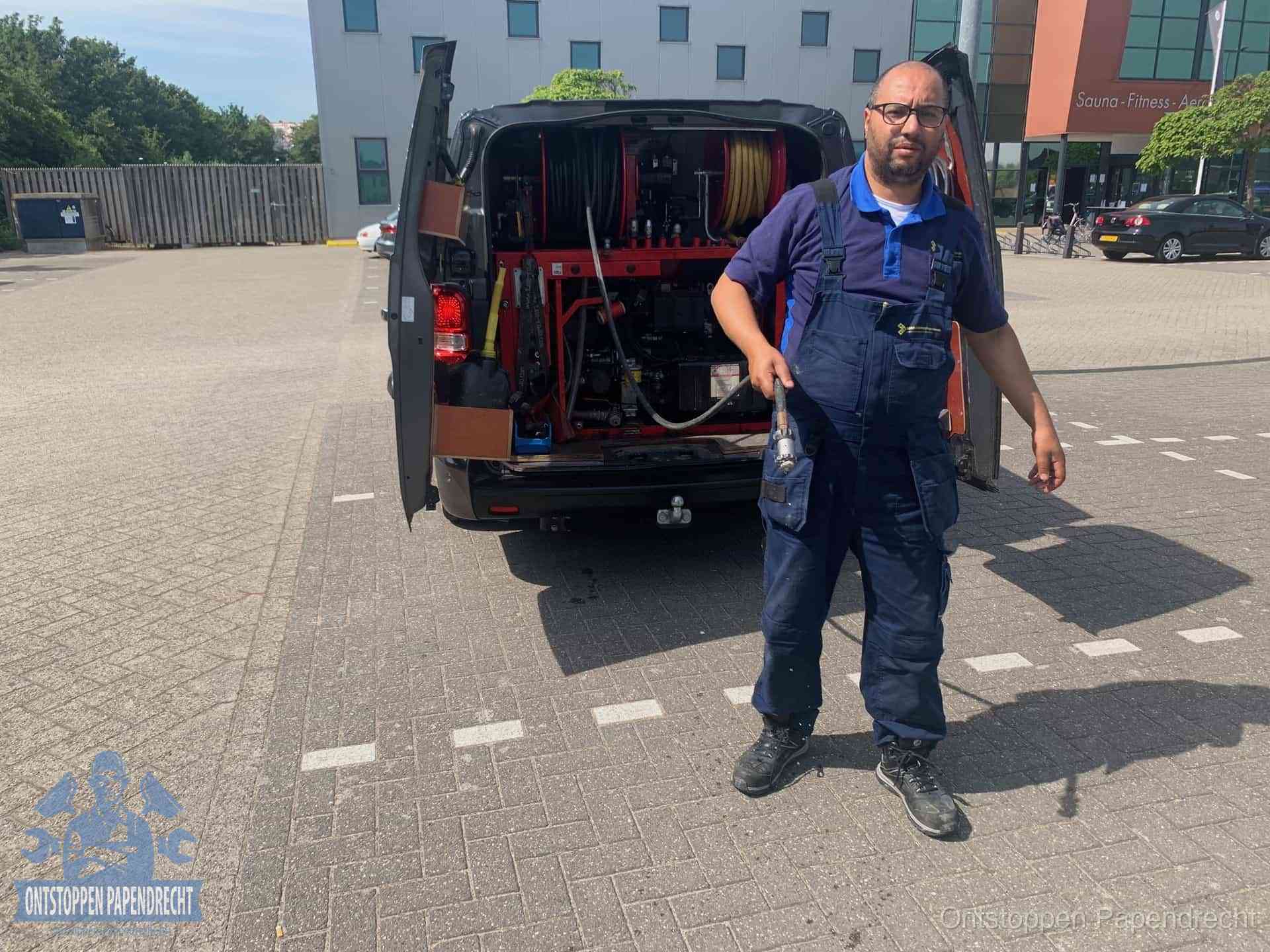 Een monteur bij zijn bestelbus met een hogedruk- en rioolreinigingsunit, klaar om de oorzaak van terugkerende wc-verstoppingen aan te pakken in Papendrecht